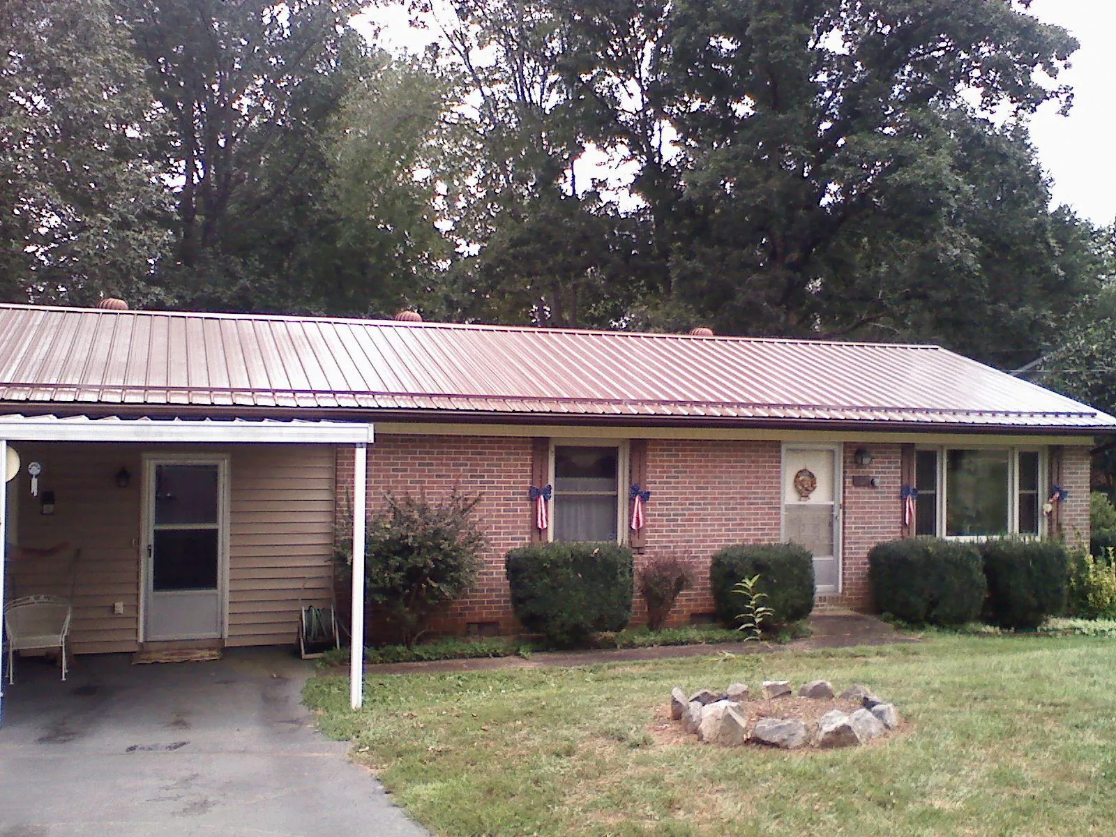 Bronze metal roof and carport on a brick ranch home — Roof Repair work by our crew in Rathdrum